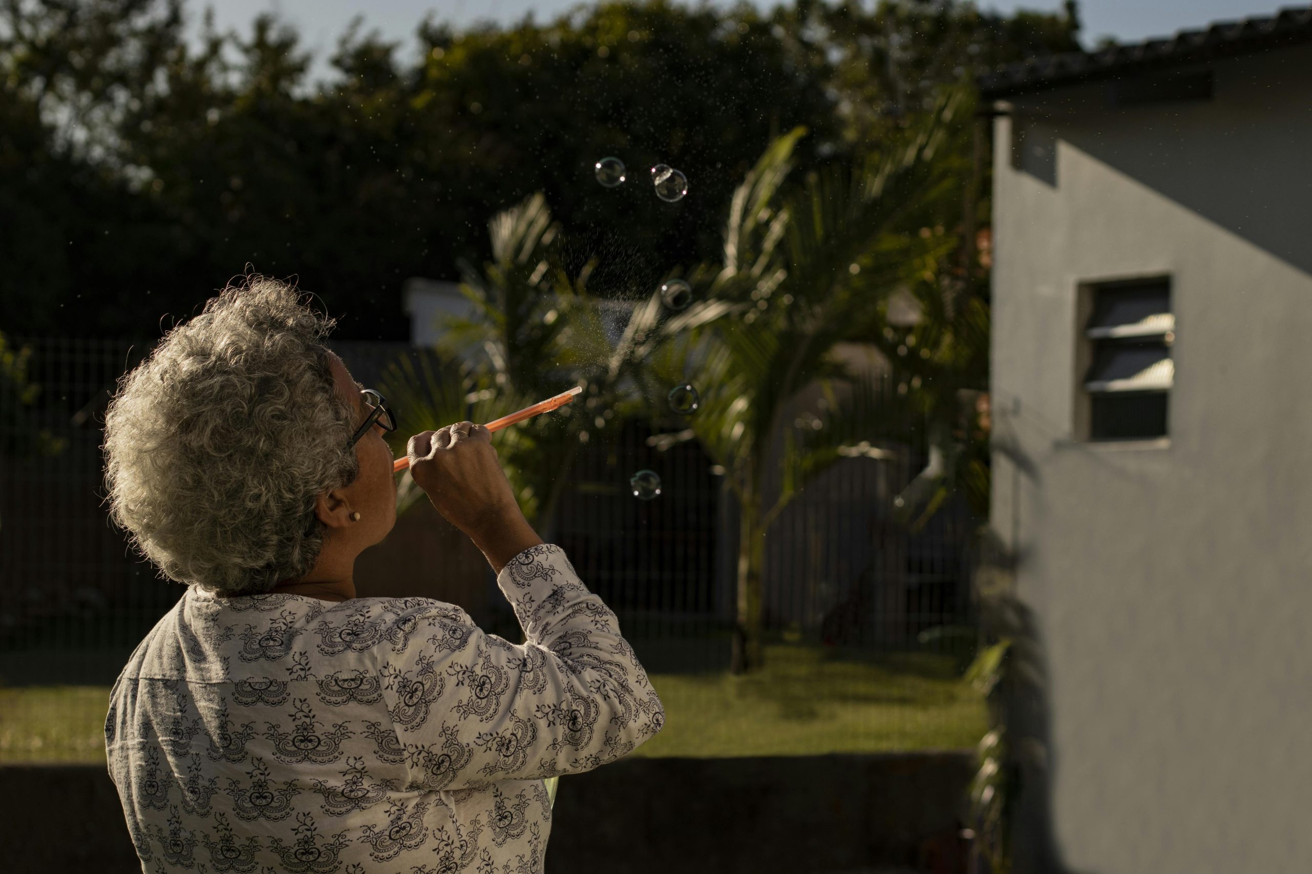 Elderly woman blowing bubbles